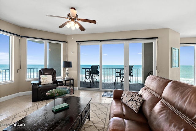 living room featuring ceiling fan, a water view, and light tile patterned flooring