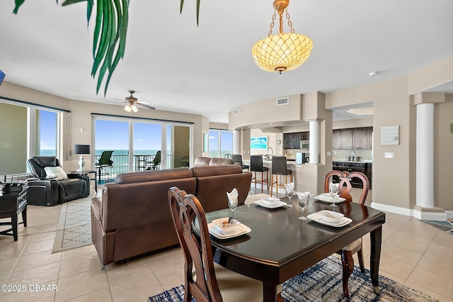 dining space with sink, light tile patterned floors, ceiling fan, and a wealth of natural light