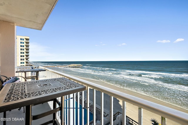 balcony featuring a beach view and a water view