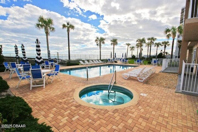 view of swimming pool featuring a patio area and a hot tub