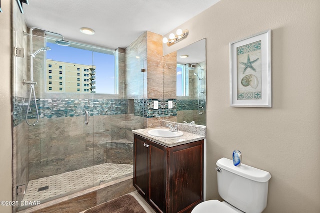 bathroom featuring toilet, a shower with door, and vanity