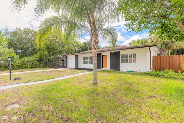 single story home featuring a garage and a front yard