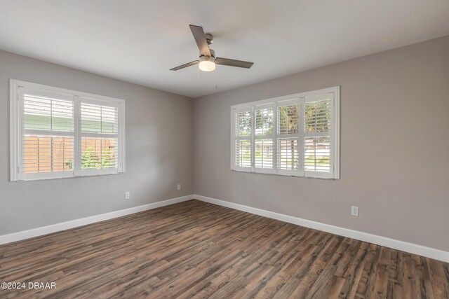 empty room featuring dark hardwood / wood-style flooring and ceiling fan