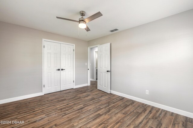 unfurnished bedroom with a closet, ceiling fan, and dark hardwood / wood-style floors