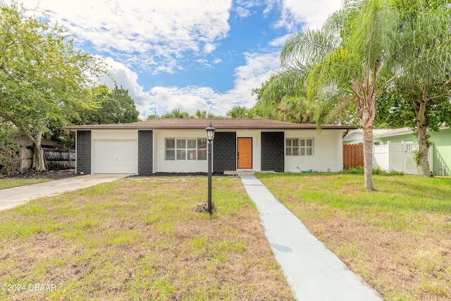 ranch-style home with a garage and a front lawn