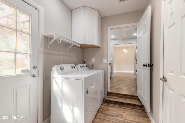 laundry room with cabinets, washer and dryer, and dark hardwood / wood-style floors