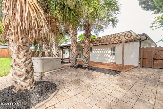 view of patio with a hot tub and a pergola