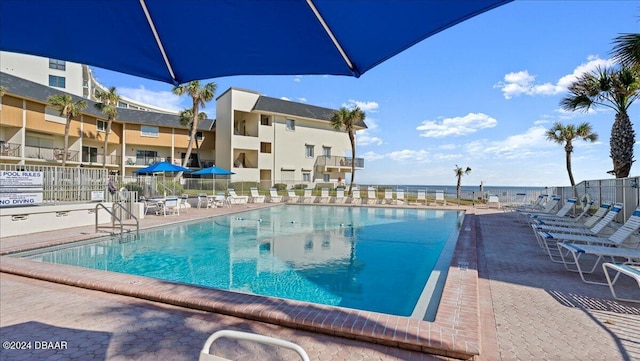 view of swimming pool with a water view and a patio area