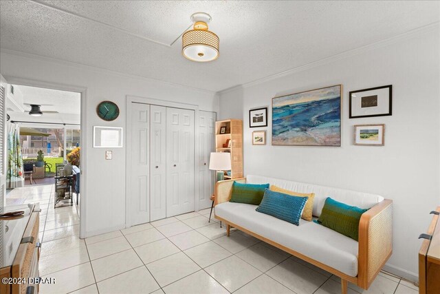 sitting room featuring a textured ceiling, light tile patterned floors, and ornamental molding