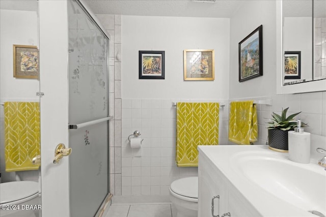 bathroom featuring tile walls, a textured ceiling, and toilet