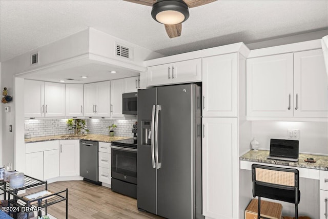 kitchen with light hardwood / wood-style flooring, white cabinetry, and stainless steel appliances