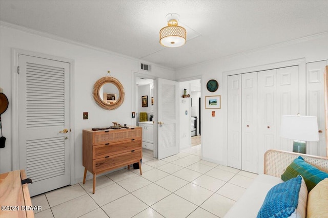 bedroom featuring a textured ceiling, light tile patterned floors, and crown molding