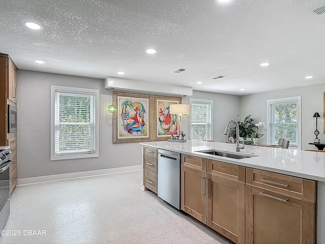 kitchen featuring a sink, stainless steel appliances, recessed lighting, baseboards, and light countertops
