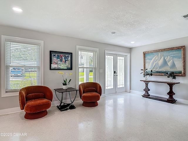 sitting room with baseboards, french doors, a textured ceiling, speckle patterned floor, and recessed lighting