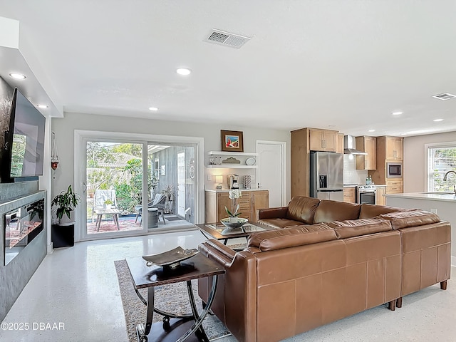 living area featuring recessed lighting and dark aggregate flooring