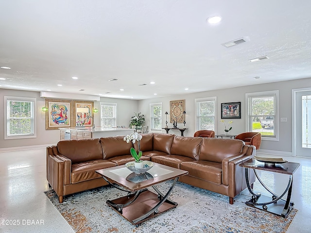 living room featuring recessed lighting, healthy amount of natural light, and baseboards
