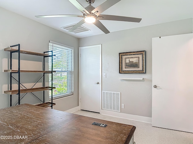 unfurnished office with ceiling fan, baseboards, and speckle patterned floor