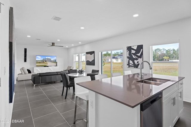 kitchen with white cabinetry, sink, ceiling fan, stainless steel dishwasher, and an island with sink