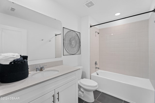 full bathroom featuring tile patterned floors, vanity, tiled shower / bath combo, and toilet