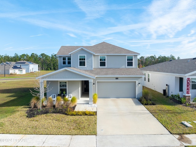 view of front of home featuring a front yard, a garage, and covered porch