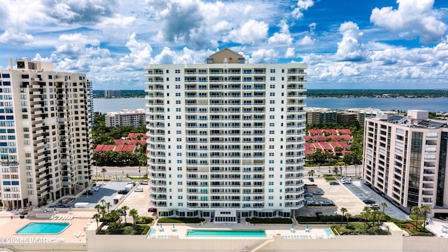 view of property with a community pool and a water view