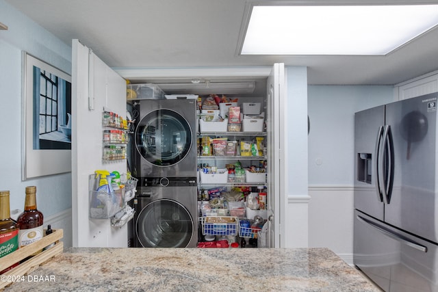 pantry featuring stacked washer and dryer