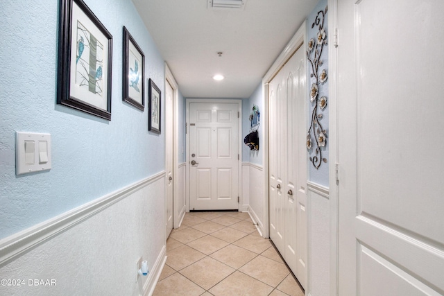 2937 S Atlantic Ave Unit 1504, Daytona Beach Shores, FL 32118 - entryway featuring light tile patterned floors, a textured wall, and wainscoting