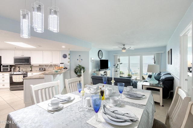 tiled dining space featuring ceiling fan