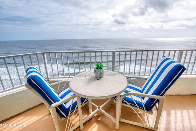 balcony featuring a water view and a beach view