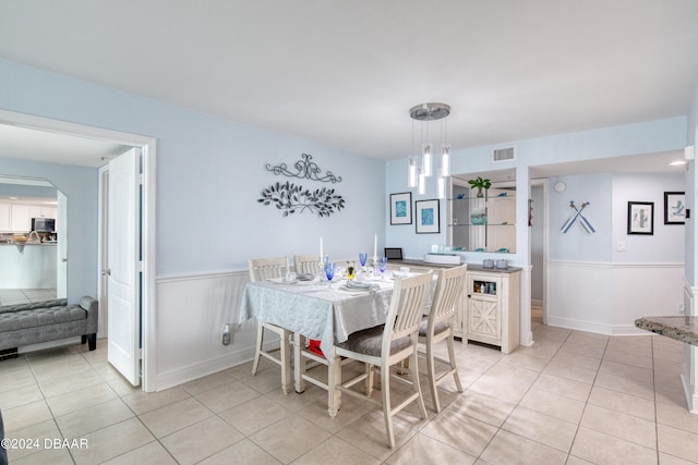 tiled dining area featuring an inviting chandelier