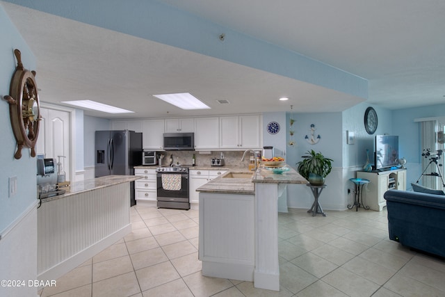 kitchen featuring sink, appliances with stainless steel finishes, tasteful backsplash, light tile patterned floors, and white cabinets