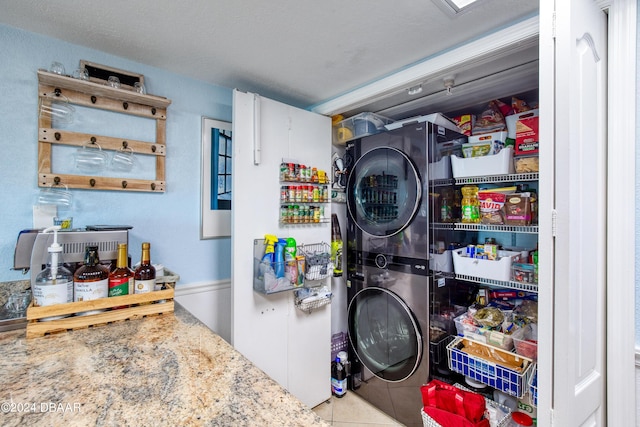 2937 S Atlantic Ave Unit 1504, Daytona Beach Shores, FL 32118 - clothes washing area with stacked washing machine and dryer and tile patterned flooring