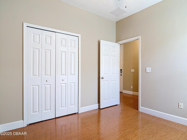 417 Grande Sunningdale Loop, Daytona Beach, FL 32124 - unfurnished bedroom with light wood-type flooring, a closet, and baseboards