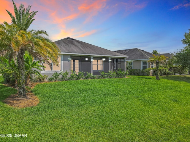 417 Grande Sunningdale Loop, Daytona Beach, FL 32124 - ranch-style house with a sunroom, a front lawn, and stucco siding
