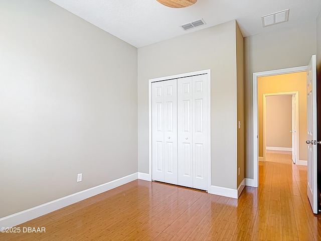 417 Grande Sunningdale Loop, Daytona Beach, FL 32124 - unfurnished bedroom with light wood-style flooring, baseboards, and a closet