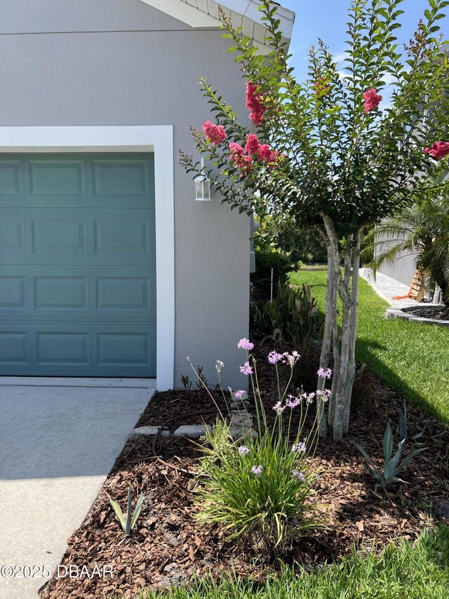 417 Grande Sunningdale Loop, Daytona Beach, FL 32124 - view of exterior entry featuring stucco siding and a garage