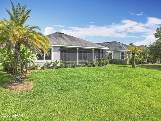 417 Grande Sunningdale Loop, Daytona Beach, FL 32124 - back of property with a sunroom, a lawn, and stucco siding