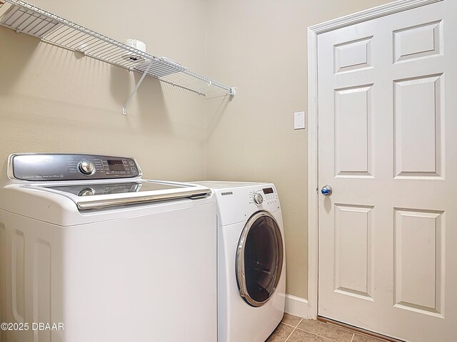 417 Grande Sunningdale Loop, Daytona Beach, FL 32124 - laundry area featuring separate washer and dryer, light tile patterned flooring, and baseboards