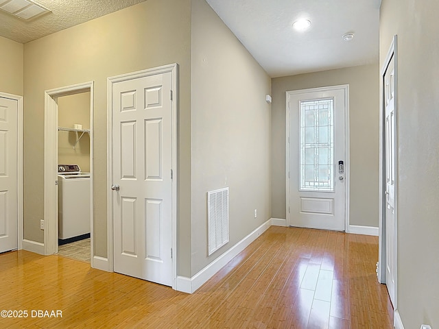 417 Grande Sunningdale Loop, Daytona Beach, FL 32124 - foyer featuring washer / dryer, light wood-style floors, and baseboards