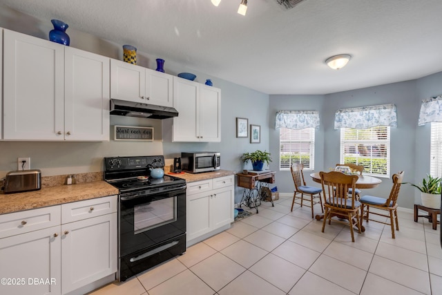 448 White Coral Ln, New Smyrna Beach, FL 32168 - kitchen with black range with electric cooktop, stainless steel microwave, under cabinet range hood, light countertops, and white cabinets