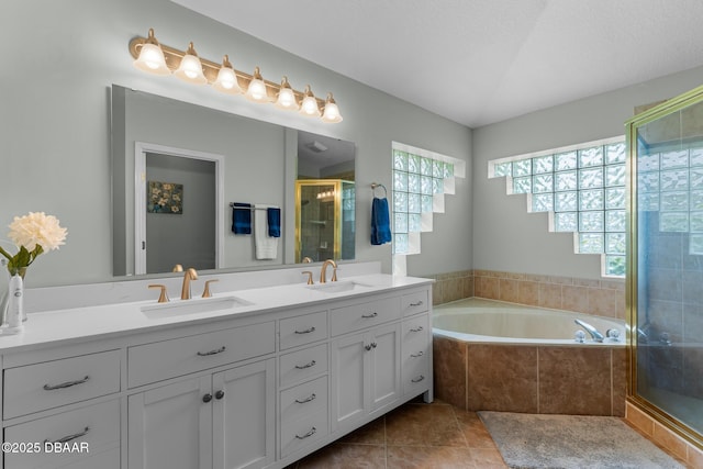 bathroom featuring double vanity, a stall shower, a sink, and tile patterned floors