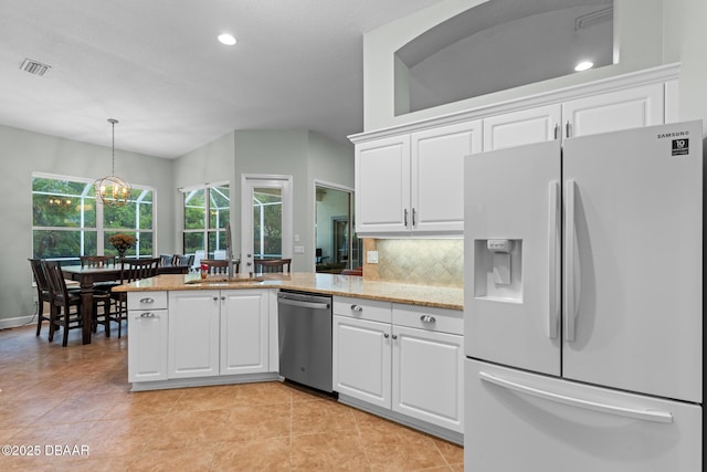 kitchen with white cabinets, stainless steel dishwasher, decorative backsplash, white fridge with ice dispenser, and decorative light fixtures