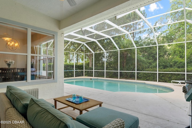 outdoor pool with glass enclosure, a patio, outdoor lounge area, and ceiling fan