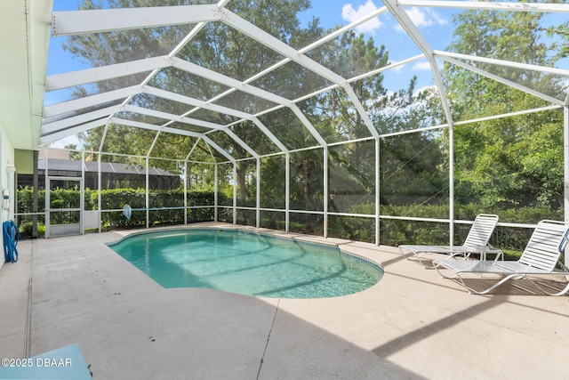 outdoor pool featuring glass enclosure and a patio area