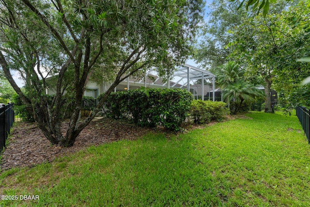 view of yard with a lanai and fence