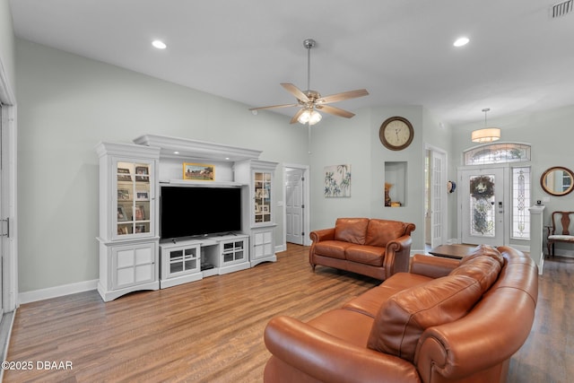 living area with recessed lighting, visible vents, baseboards, and wood finished floors