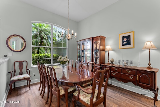 dining area featuring dark wood-style floors, plenty of natural light, and an inviting chandelier