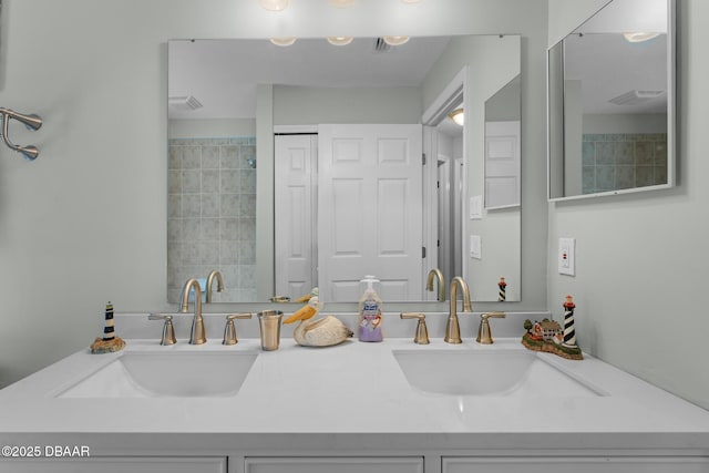 bathroom featuring visible vents, a sink, and double vanity