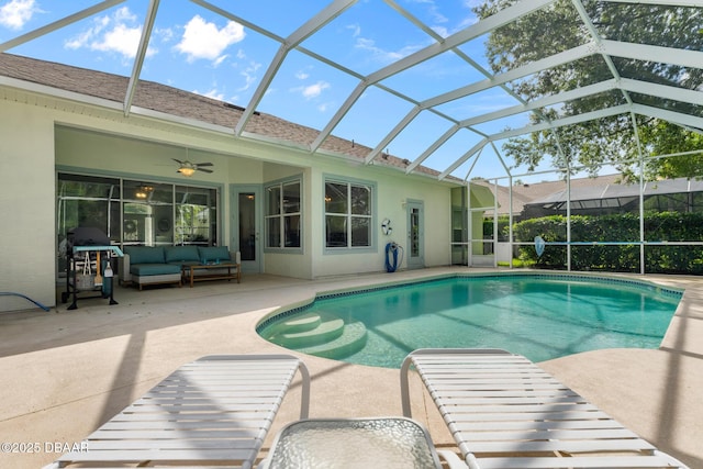 outdoor pool featuring an outdoor hangout area, glass enclosure, a patio, and a ceiling fan