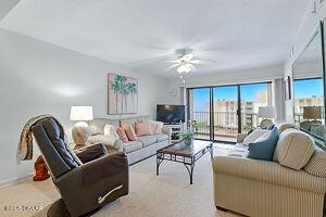 4175 S Atlantic Ave Unit 405, New Smyrna Beach, FL 32169 - carpeted living area featuring a ceiling fan